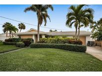 Single-story home with lush landscaping and palm trees at 1386 40Th Ne Ave, St Petersburg, FL 33703