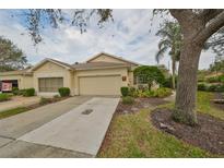 Front view of charming house with attached garage and well-manicured landscaping at 2620 Newcomb Ct, Sun City Center, FL 33573