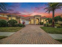 Beautiful two-story home with a three-car garage and brick paver driveway at 8478 Dunham Station Dr, Tampa, FL 33647