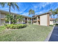 Two-story condo building with lush landscaping and palm trees at 19029 Us Highway 19 N # 3-13, Clearwater, FL 33764