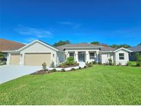 Single-story home with three-car garage and landscaped lawn at 295 Woodstream Way, Spring Hill, FL 34608