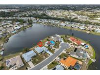 Waterfront home with a mature landscaped lawn and an attached two-car garage on a quiet cul-de-sac at 407 Blackhawk Cir, Sun City Center, FL 33573