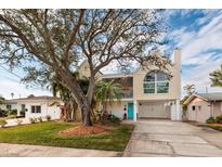 Charming two-story coastal home featuring a bright blue front door and lush landscaping in a beautiful waterfront community at 5946 Bayou Grande Ne Blvd, St Petersburg, FL 33703