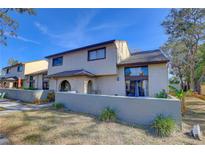 Two-story townhome with a gray exterior, landscaping, and a private patio at 6262 142Nd N Ave # 505, Clearwater, FL 33760