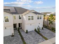 This aerial view shows a townhome with a paved driveway, solar panels, and well-maintained landscaping at 2391 Summerlit St, Lutz, FL 33558