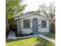Charming single-story home featuring a blue front door, landscaped yard, and a well-maintained lawn at 3424 Queensboro S Ave, St Petersburg, FL 33711