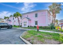Beautiful pink building with palm trees and well-maintained landscaping, offering a vibrant and welcoming curb appeal at 4827 Coquina Key Se Dr # B, St Petersburg, FL 33705