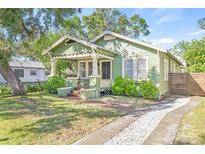 Light green craftsman home with a spacious front yard and walkway at 213 W Cayuga St, Tampa, FL 33603