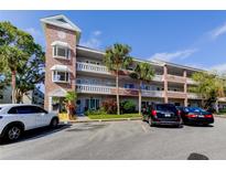 Condominium exterior featuring brick accents, balconies, and well-maintained landscaping at 2460 Persian Dr # 26, Clearwater, FL 33763