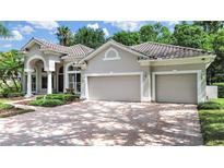 Beautiful home exterior features a two-car garage, paved driveway, manicured landscaping, and a tile roof at 10106 Radcliffe Dr, Tampa, FL 33626