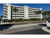 Multi-story building with ocean view, palm trees, and ample parking at 19418 Gulf Blvd # 506, Indian Shores, FL 33785