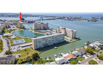 Aerial view of waterfront community with multiple buildings, tennis courts, and boat slips at 4525 Cove Cir # 1002, St Petersburg, FL 33708