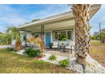 Charming home featuring a welcoming front porch with stylish seating and lush tropical landscaping at 5901 1St Ne St, St Petersburg, FL 33703