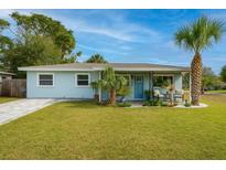 Charming single-story home with a well-manicured lawn and tropical landscaping, freshly painted light blue at 5901 1St Ne St, St Petersburg, FL 33703