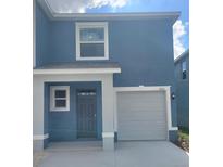 Charming two-story blue house with a single-car garage and well-maintained landscaping at 11851 Davis Dr, Largo, FL 33774