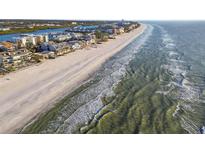 Aerial view of a pristine white sand beach with clear blue water along a coastline at 20001 Gulf Blvd # 501, Indian Shores, FL 33785