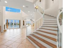 Bright entryway features a winding staircase, high ceilings, and a view of the waterfront at 6015 Kipps Colony E Dr, Gulfport, FL 33707