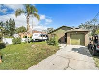 Charming single-story home with a well-maintained lawn, a palm tree, and driveway parking at 6726 S Sheridan Rd, Tampa, FL 33611