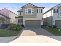 Two-story house with gray siding, gray garage door, and landscaped front yard at 8280 Rolling Tides Dr, New Port Richey, FL 34655