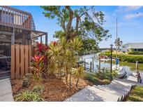 Waterfront backyard with private dock, lush landscaping, and canal views at 9386 Tradewinds Ave, Seminole, FL 33776