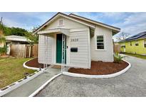 Charming bungalow with a green door, landscaped yard, and a paved pathway at 3409 Tarlton N St, St Petersburg, FL 33713