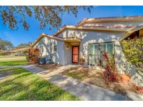 Well-maintained villa with a red door, walkway, and landscaping at 2035 Nash Dr, Clearwater, FL 33763