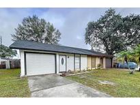 Inviting one-story home boasting a well-maintained lawn, attached garage, and white trimmed windows at 22702 Penny Loop, Land O Lakes, FL 34639