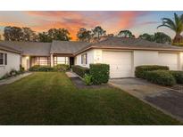 Exterior view of a charming villa with a two-car garage and well-manicured lawn at 3309 Lori Ln, New Port Richey, FL 34655