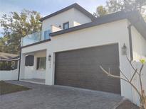 Two-story modern home with dark brown garage door and glass balcony at 122 W Sligh Ave, Tampa, FL 33604