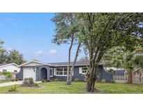 Newly renovated home with gray exterior, white garage door, and landscaped yard at 15111 Verona Ave, Clearwater, FL 33760