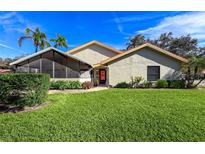 Charming home with manicured lawn, mature landscaping, a screened porch and a welcoming entrance at 2281 Lake Arbor Blvd, Clearwater, FL 33763