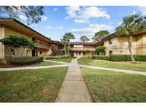 Exterior view of condo building with walkway and landscaping at 2679 Sabal Springs Cir # 203, Clearwater, FL 33761