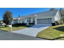 Front view of a single-story house with a garage and landscaped lawn at 9336 Villa Entrada, New Port Richey, FL 34655