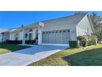 Charming single story home featuring a well-maintained lawn, gray roof and attached two-car garage at 9336 Villa Entrada, New Port Richey, FL 34655