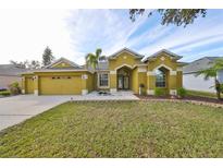 Attractive one-story house with a three-car garage and well-manicured lawn at 9415 Sayre St, Riverview, FL 33569