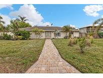 Brick ranch home with a landscaped lawn and brick walkway at 512 Acacia Ln, Nokomis, FL 34275