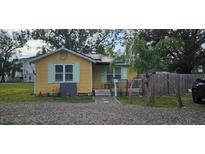 Cute yellow cottage with solar panels, small deck, and fenced yard at 6404 Pershing Ne St, St Petersburg, FL 33702