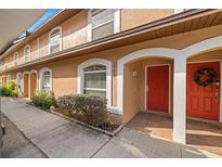 Exterior view of townhouse with red door and landscaping at 14625 Par Club Cir, Tampa, FL 33618