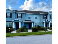Charming townhomes with manicured lawns, blue siding, black shutters, and white trim at 2409 Hearth Dr, Odessa, FL 33556