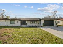 Stunning curb appeal featuring a renovated single-story home with modern facade and landscaped lawn at 26728 Hickory Loop, Lutz, FL 33559