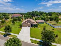 Sprawling single Gathering home with large yard, ample landscaping, and a private driveway, under a partly cloudy sky at 3406 Ranchdale Dr, Plant City, FL 33566