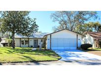 One-story house with attached garage, and landscaped lawn at 8040 Pasadena Dr, Port Richey, FL 34668