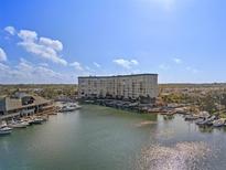 Stunning aerial view of waterfront condo building and marina under a bright blue sky at 4939 Floramar Ter # 501, New Port Richey, FL 34652