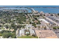 Aerial view showing condo community near the water, with a pool and surrounding neighborhood at 215 Valencia Blvd # 105, Belleair Bluffs, FL 33770