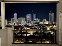 Balcony view of the city at night, featuring lit buildings against the dark sky at 226 5Th N Ave # 1502, St Petersburg, FL 33701
