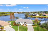 Waterfront home featuring lush landscaping, mature trees, and a charming archway entrance at 7233 15Th Ne Ct, St Petersburg, FL 33702