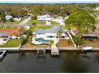 Aerial view of waterfront home with pool, dock, and lush landscaping on a sunny day at 5321 Dover Ne St, St Petersburg, FL 33703