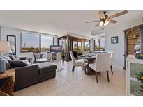 Open-concept living space features large windows, a modern sectional, and a dining area with balcony access at 6104 Palma Del Mar S Blvd # 404, St Petersburg, FL 33715