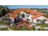 Elegant home featuring a red tile roof, arched entryway, mature landscaping, and brick driveway at 751 34Th Ne Ave, St Petersburg, FL 33704