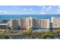 Beautiful view of the condo building with tennis court and waterfront views on a bright, sunny day at 6009 Sea Ranch Dr # 303, Hudson, FL 34667